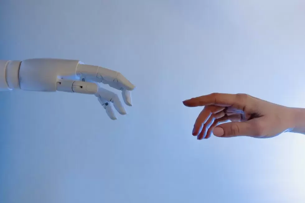 Robot hand reikt naar menselijke hand